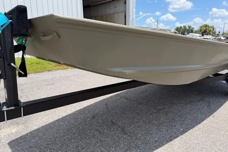 Slide: The Image of 2027 Tracker Grizzly 15 Jon boat on trailer, parked outdoors under blue sky. - 25