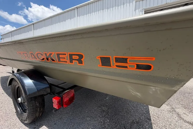 Slide: The Image of 2027 Tracker Grizzly 15 Jon boat on trailer, featuring bold orange lettering. - 22