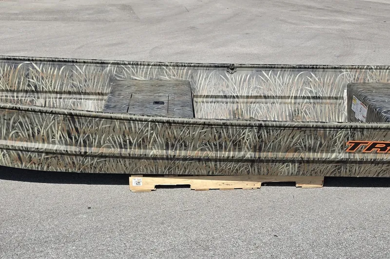 The Image of 2027 Tracker Grizzly 15 Jon boat with camouflage design on a wooden pallet. - 0