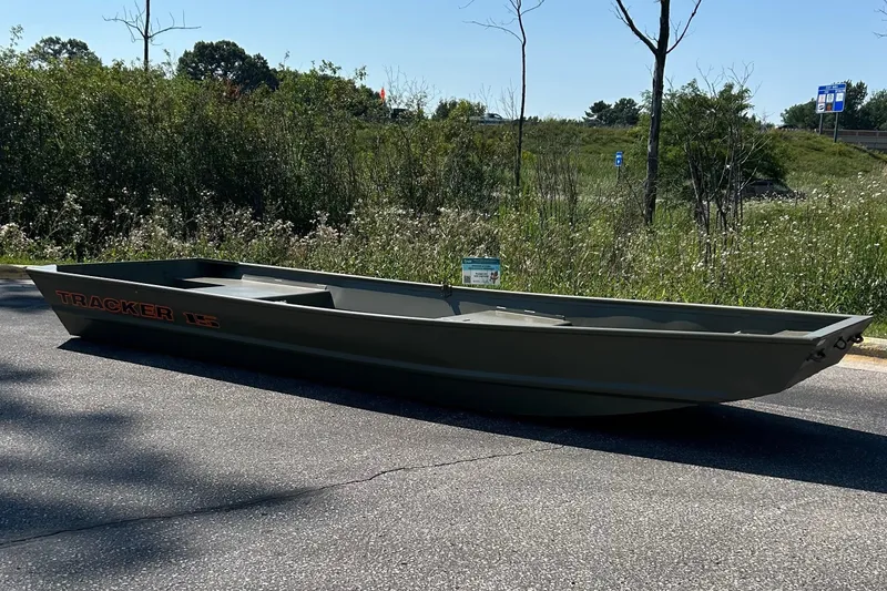 The Image of 2027 Tracker Grizzly 15 Jon boat on roadside, surrounded by greenery. - 0