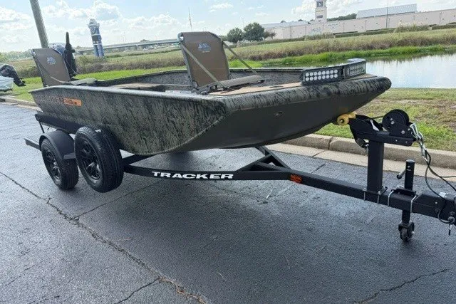 The Image of 2027 Tracker Grizzly 1553 Timber boat on trailer, parked near a waterway. - 0