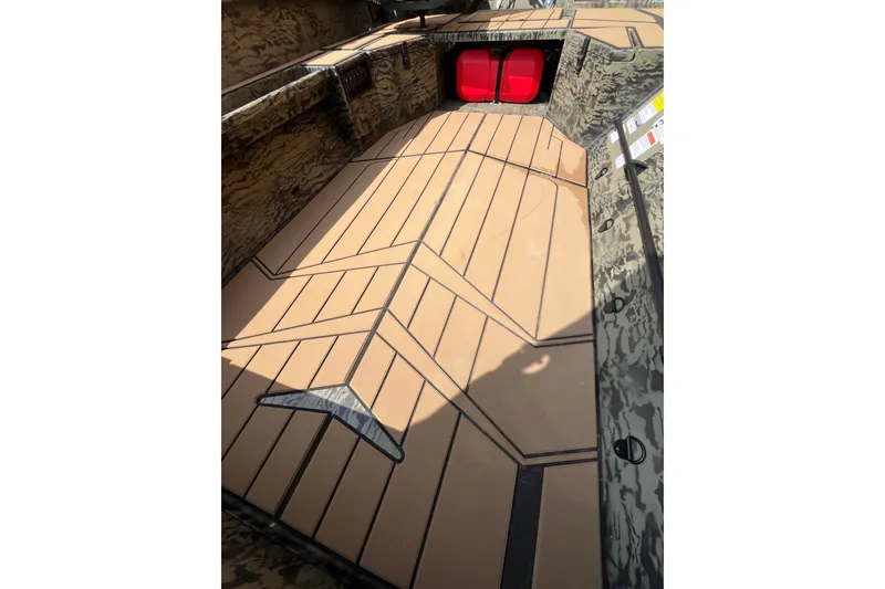 Slide: The Image of 2027 Tracker Grizzly 1553 Timber boat interior with camo design and red storage compartment. - 42
