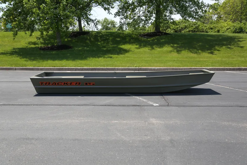 The Image of 2027 Tracker Grizzly 15 Jon boat parked on asphalt with green grass background. - 0