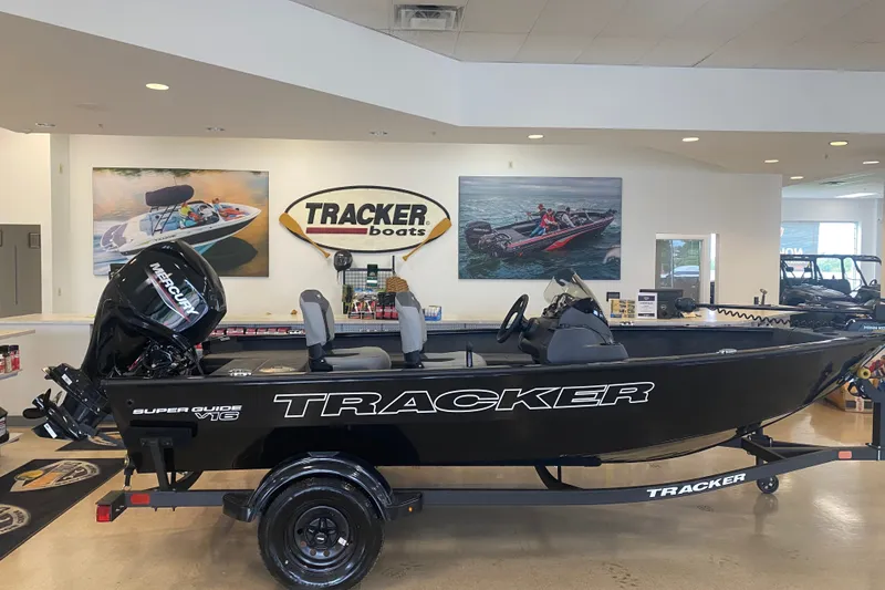 The Image of 2027 Tracker Super Guide V-16 SC boat displayed in showroom with Mercury engine. - 0