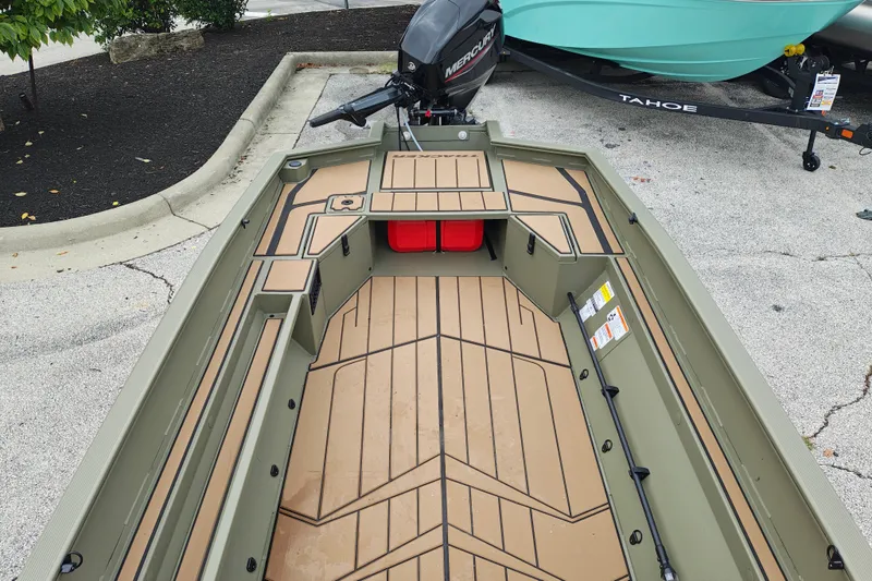 Slide: The Image of 2027 Tracker Grizzly 1553 Timber boat interior with Mercury engine, parked on pavement. - 16