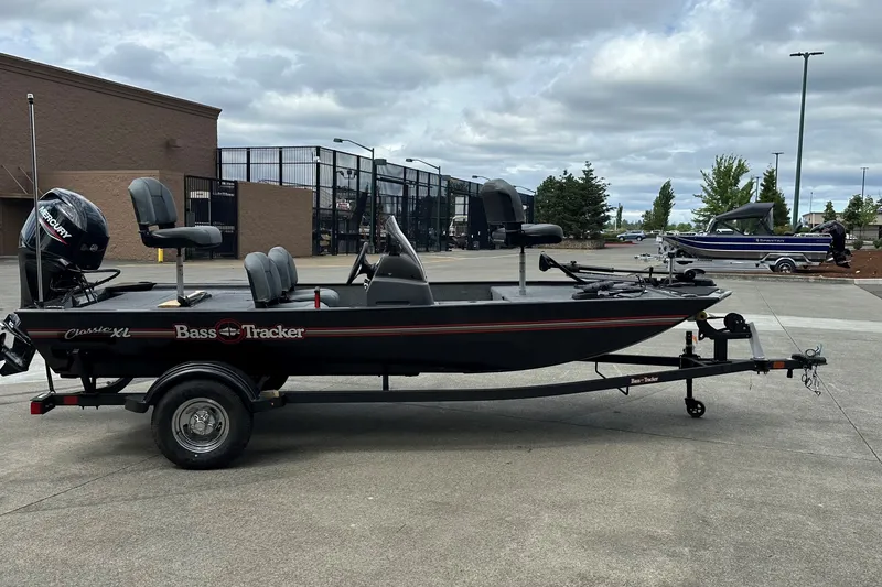 The Image of 2027 Tracker Bass Tracker Classic XL boat on trailer, parked outdoors. - 0