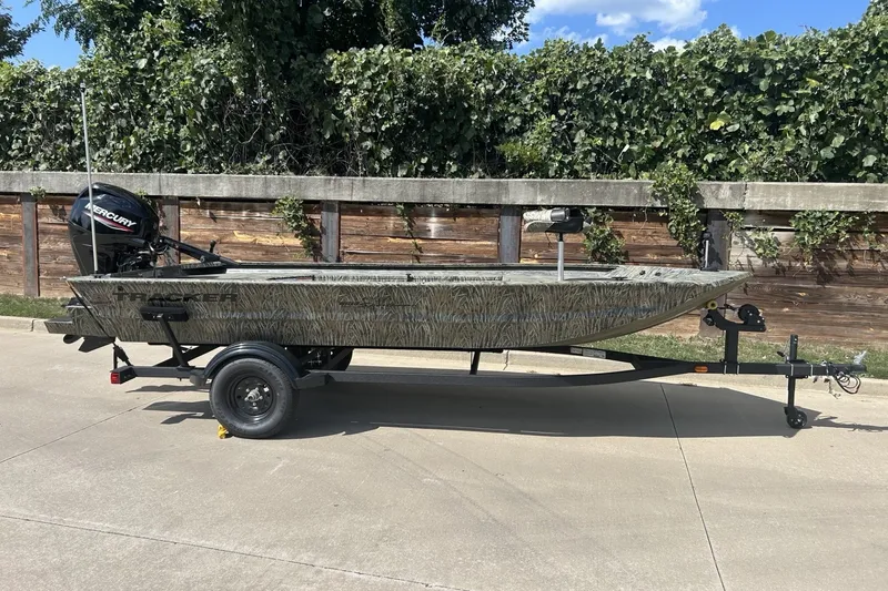 The Image of 2027 Tracker Grizzly 1654 T Sportsman boat on trailer, parked outdoors. - 0