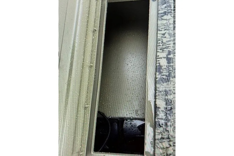 Slide: The Image of Interior compartment of 2027 Tracker Grizzly 1654 T Sportsman boat, showing water droplets. - 14