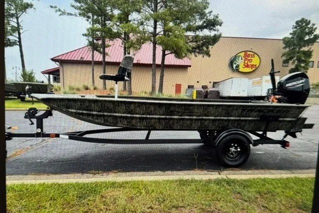 The Image of 2027 Tracker Grizzly 1654 T Sportsman boat on trailer outside Bass Pro Shops. - 0