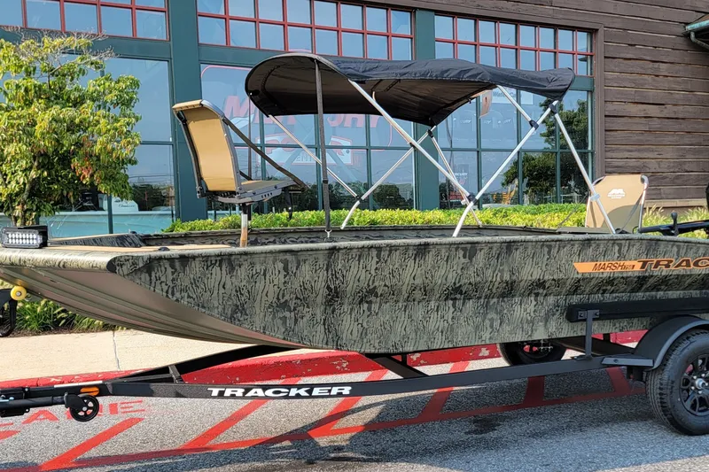 The Image of 2027 Tracker Grizzly 1756 T Marsh boat with canopy on trailer, parked outdoors. - 0