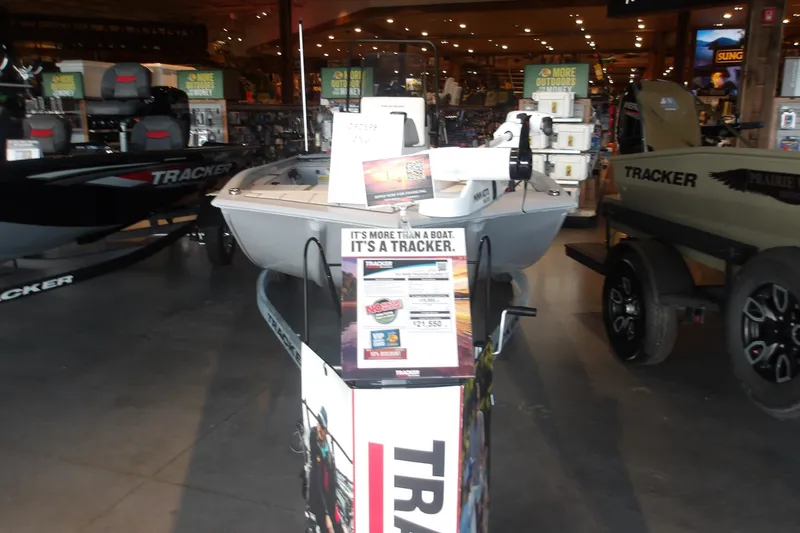 The Image of 2027 Tracker Bass Tracker Classic CC boat displayed in a showroom with promotional materials. - 0
