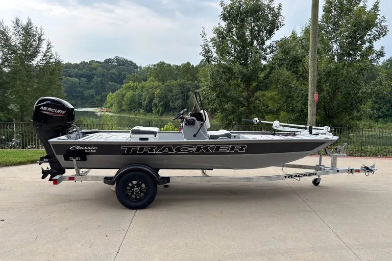 The Image of 2027 Tracker Bass Tracker Classic CC boat on trailer, parked near a scenic lake. - 0
