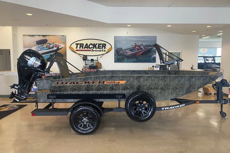 The Image of 2027 Tracker Grizzly 1553 Timber boat displayed in showroom with Mercury outboard motor. - 0