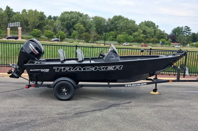The Image of 2027 Tracker Super Guide V-16 SC boat on trailer, parked outdoors. - 0