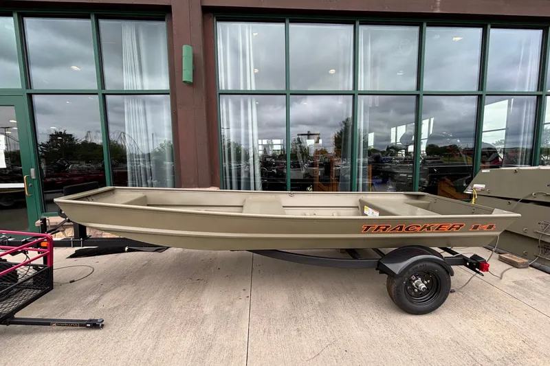 The Image of 2027 Tracker Grizzly 14 Jon boat on trailer, parked outside a building. - 0