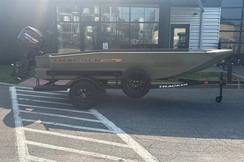 The Image of 2027 Tracker Grizzly 1553 Timber boat on trailer, parked outdoors near a building. - 0