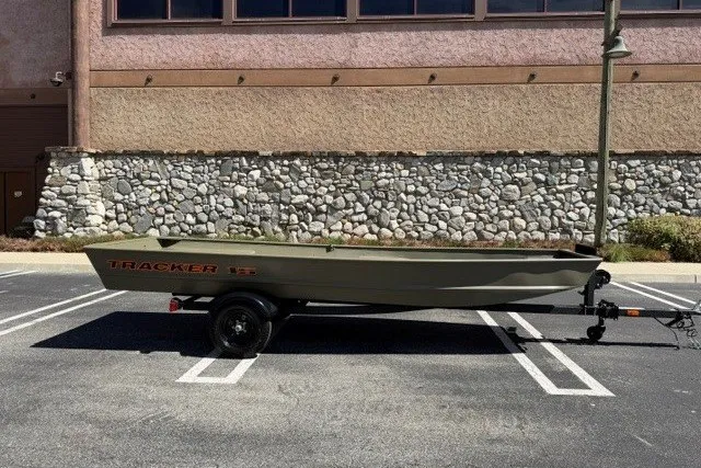 The Image of 2027 Tracker Grizzly 15 Jon boat on trailer in parking lot. - 0