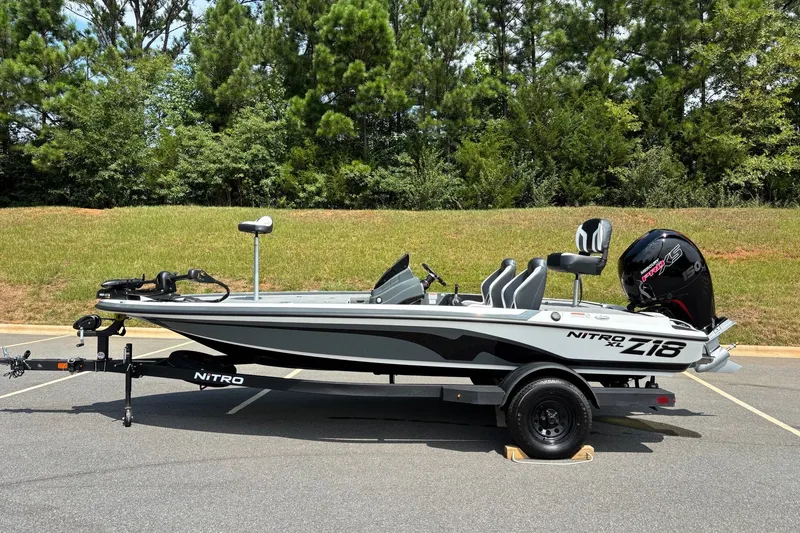 The Image of 2027 Nitro Z18 XL boat on trailer, parked outdoors with trees in background. - 0