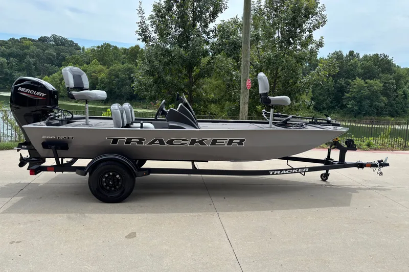 The Image of 2027 Tracker Pro 170 fishing boat on trailer, parked outdoors near a lake. - 0