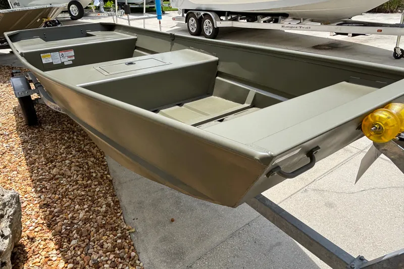 Slide: The Image of 2027 Tracker Grizzly 15 Jon boat on trailer, displayed outdoors. - 20
