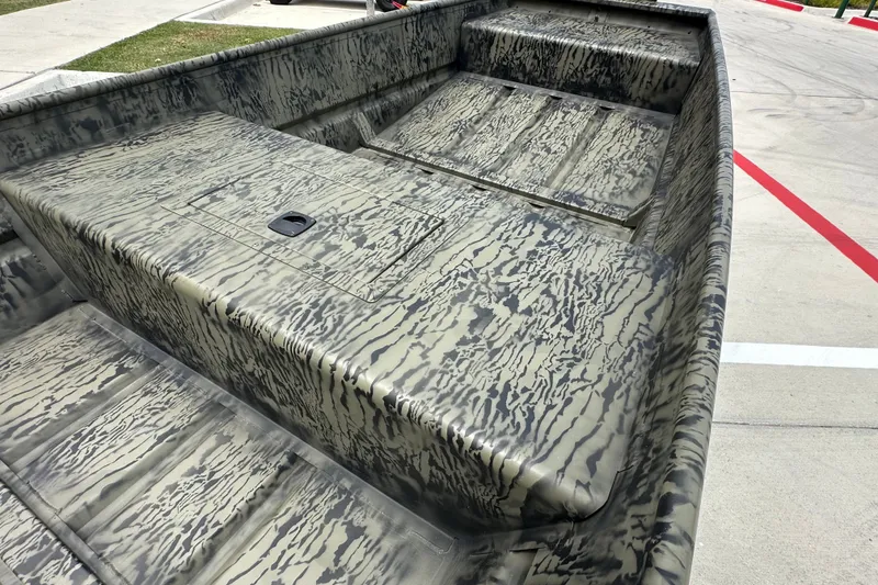 Slide: The Image of 2027 Tracker Grizzly 15 Jon boat with camouflage pattern on concrete surface. - 14