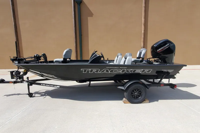The Image of 2027 Tracker Pro Team 175 boat on trailer, featuring Mercury engine, parked outdoors. - 0