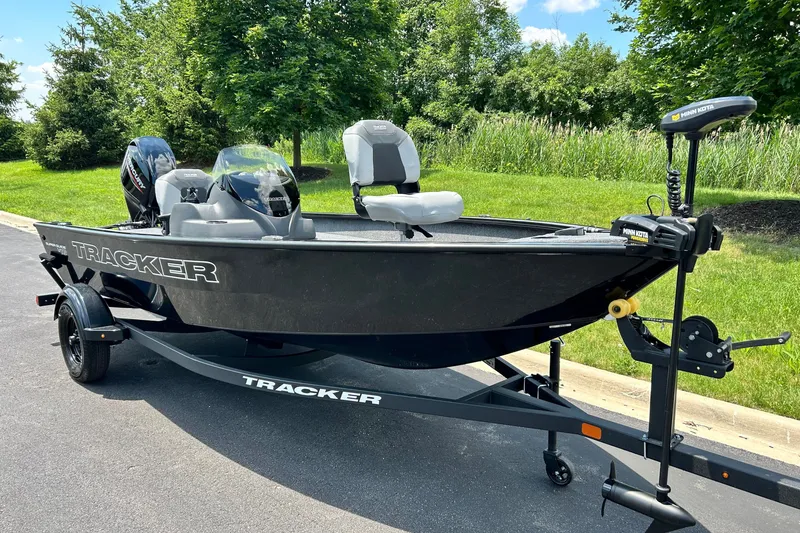 The Image of 2027 Tracker Super Guide V-16 SC boat on trailer, parked outdoors. - 0