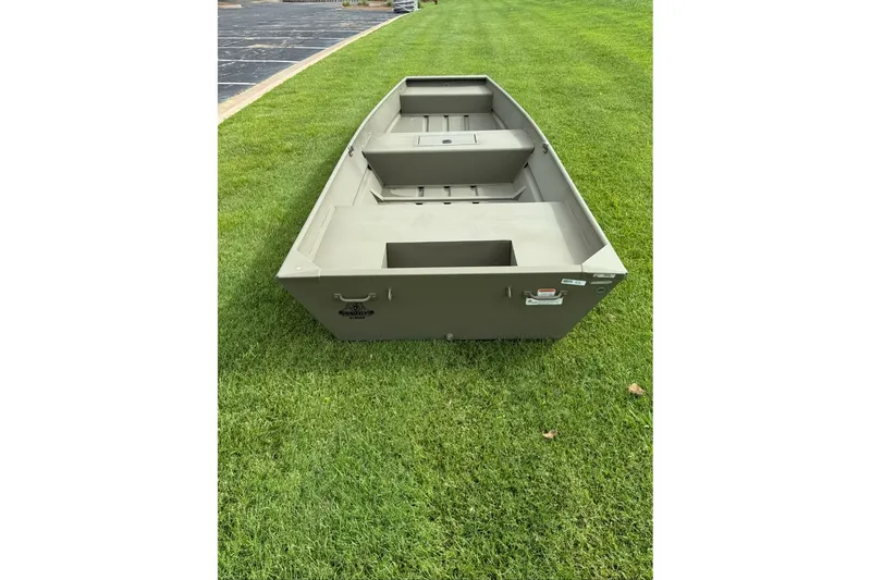 Slide: The Image of 2027 Tracker Grizzly 15 Jon boat on grass, showcasing its sturdy design. - 13