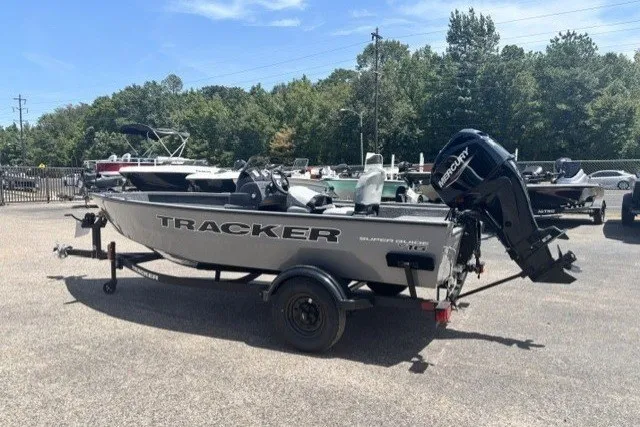 The Image of 2027 Tracker Super Guide V-16 SC boat on trailer, parked outdoors under clear sky. - 0
