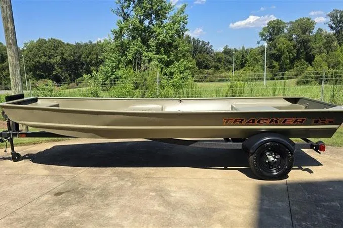 The Image of 2027 Tracker Grizzly 15 Jon boat on trailer, parked outdoors on a sunny day. - 0