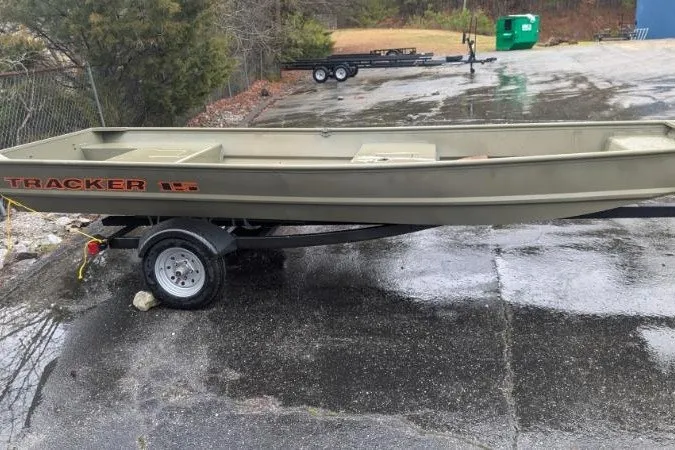 The Image of 2027 Tracker Grizzly 15 Jon boat on trailer, parked on wet pavement. - 0