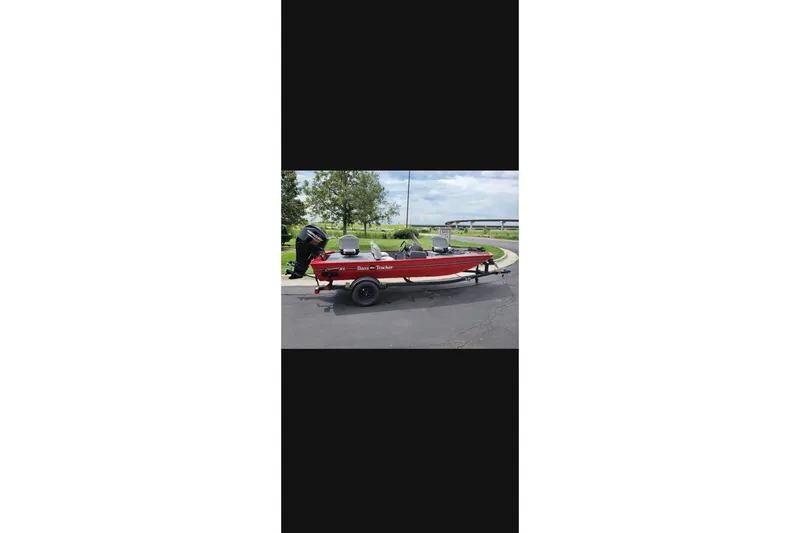 The Image of 2027 Tracker Bass Tracker Classic XL boat on trailer, parked outdoors. - 0