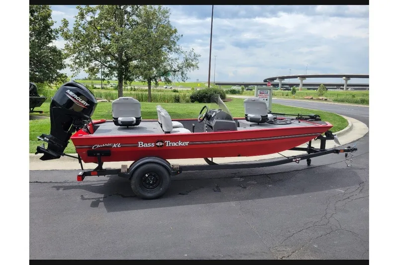 The Image of 2027 Tracker Bass Tracker Classic XL boat on trailer, parked outdoors. - 0