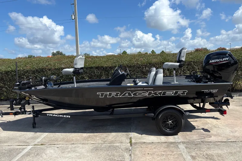 The Image of 2027 Tracker Pro Team 175 boat with Mercury engine on trailer, parked outdoors. - 0