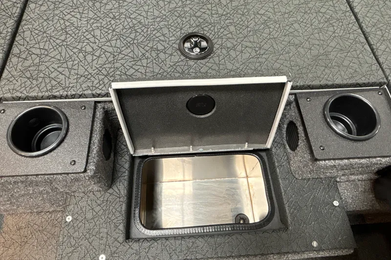 Slide: The Image of 2027 Tracker Pro Team 175 boat storage compartment with cup holders and textured surface. - 21