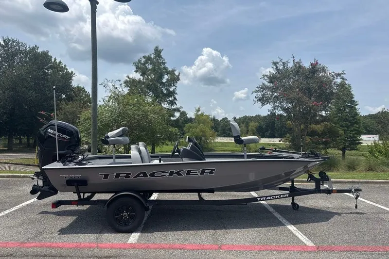 The Image of 2027 Tracker Pro Team 175 boat on trailer in parking lot, under cloudy sky. - 0