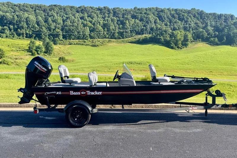 The Image of 2027 Tracker Bass Tracker Classic XL boat on trailer, scenic green landscape background. - 0