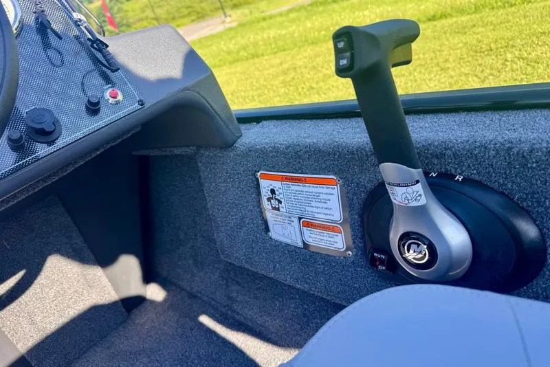 Slide: The Image of 2027 Tracker Bass Tracker Classic XL boat control panel with throttle lever and warning labels. - 16