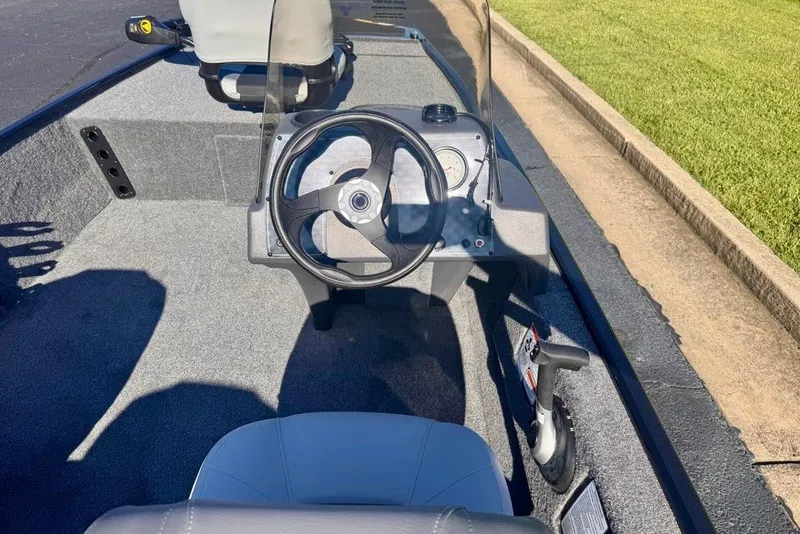 Slide: The Image of 2027 Tracker Bass Tracker Classic XL boat cockpit with steering wheel and controls. - 13