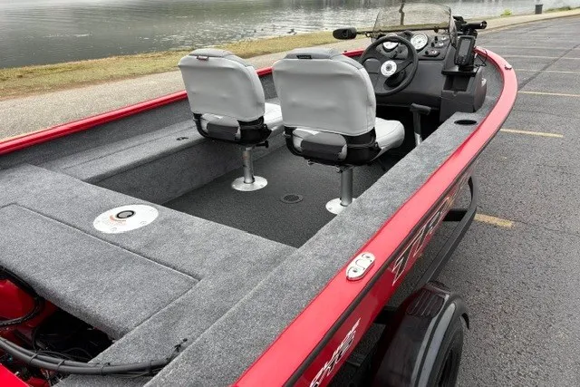 Slide: The Image of 2027 Tracker Super Guide V-16 SC boat with dual seats, red exterior, and lake view. - 14
