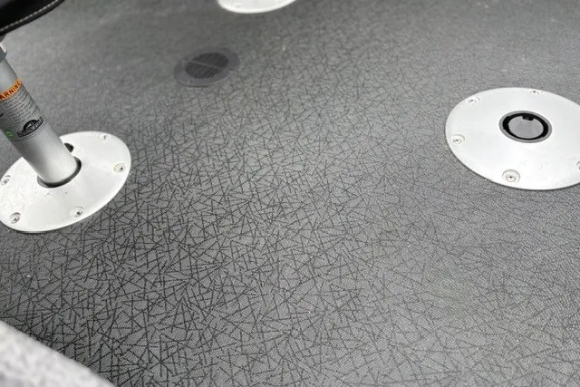 Slide: The Image of 2027 Tracker Super Guide V-16 SC boat deck with textured gray surface and metal fixtures. - 21