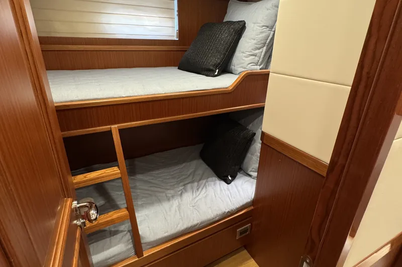 Slide: The Image of Bunk beds in 2023 Apollonian Yachts 52 Pilothouse, featuring wooden interior and cozy bedding. - 22