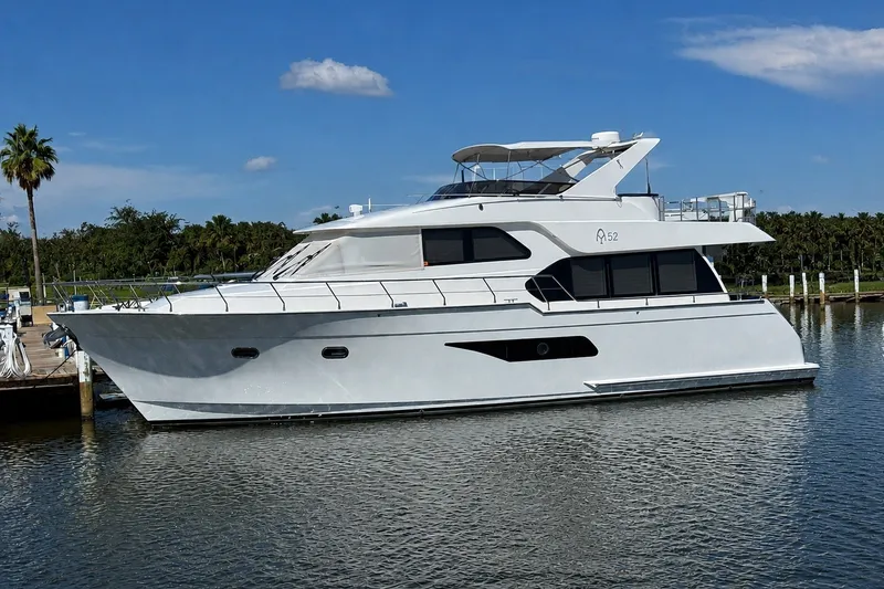 The Image of 2023 Apollonian Yachts 52 Pilothouse, sleek design, docked on calm water. - 0