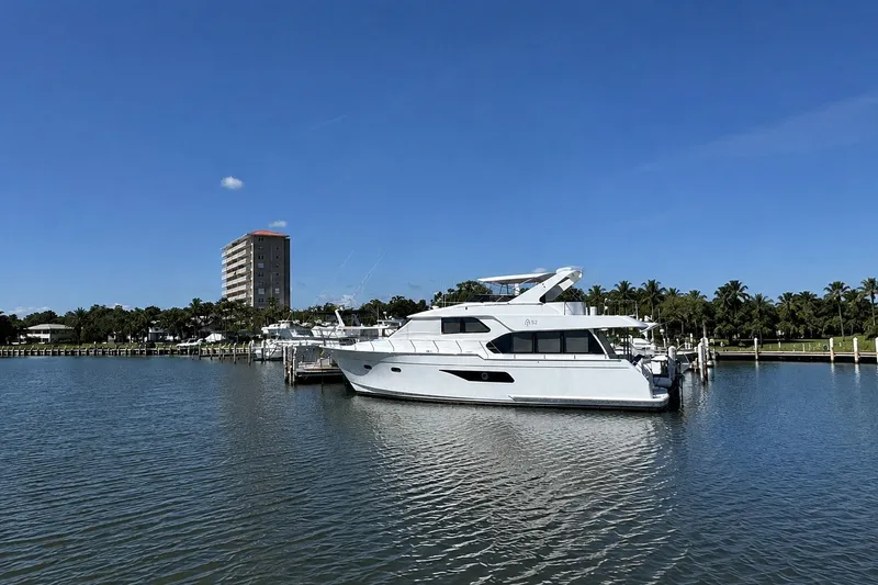 Slide: The Image of 2023 Apollonian Yachts 52 Pilothouse docked in a serene marina setting. - 2
