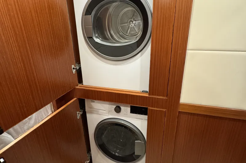 Slide: The Image of Stacked washer and dryer in 2023 Apollonian Yachts 52 Pilothouse, wooden cabinetry. - 24