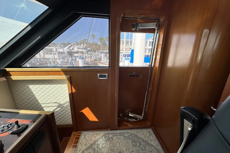 Slide: The Image of Interior view of 2023 Apollonian Yachts 52 Pilothouse, featuring elegant wood paneling and window. - 31