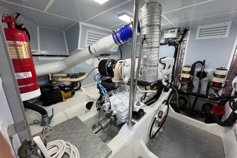 Slide: The Image of Engine room of 2023 Apollonian Yachts 52 Pilothouse with fire extinguisher and mechanical components. - 40