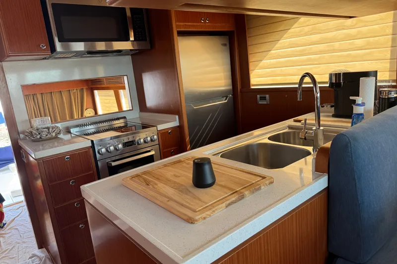 Slide: The Image of Modern kitchen interior of 2023 Apollonian Yachts 52 Pilothouse with appliances and wooden cabinetry. - 9