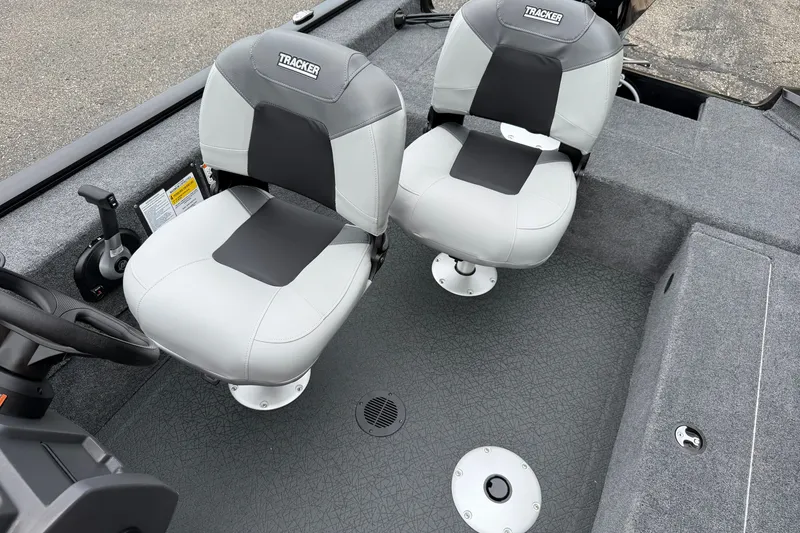 Slide: The Image of 2027 Tracker Super Guide V-16 SC boat interior with two gray seats and steering console. - 14