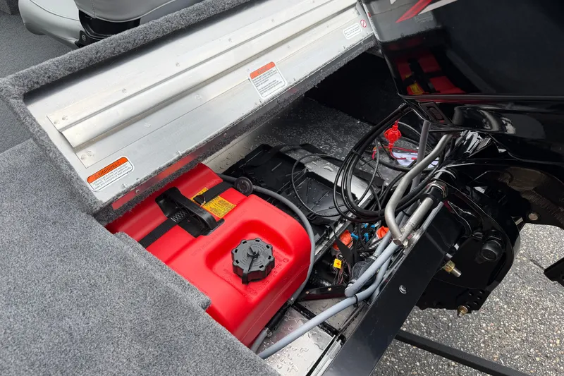 Slide: The Image of 2027 Tracker Super Guide V-16 SC boat engine compartment with red fuel tank and wiring. - 15